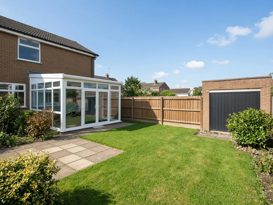 An end-of-terrace house with a garage and a conservatory