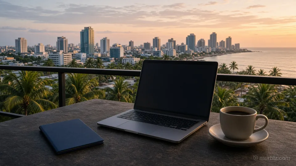 A dark blue passport, a laptop and a cup of coffee on a balcony table above palm trees and a seaside skyline at sunset